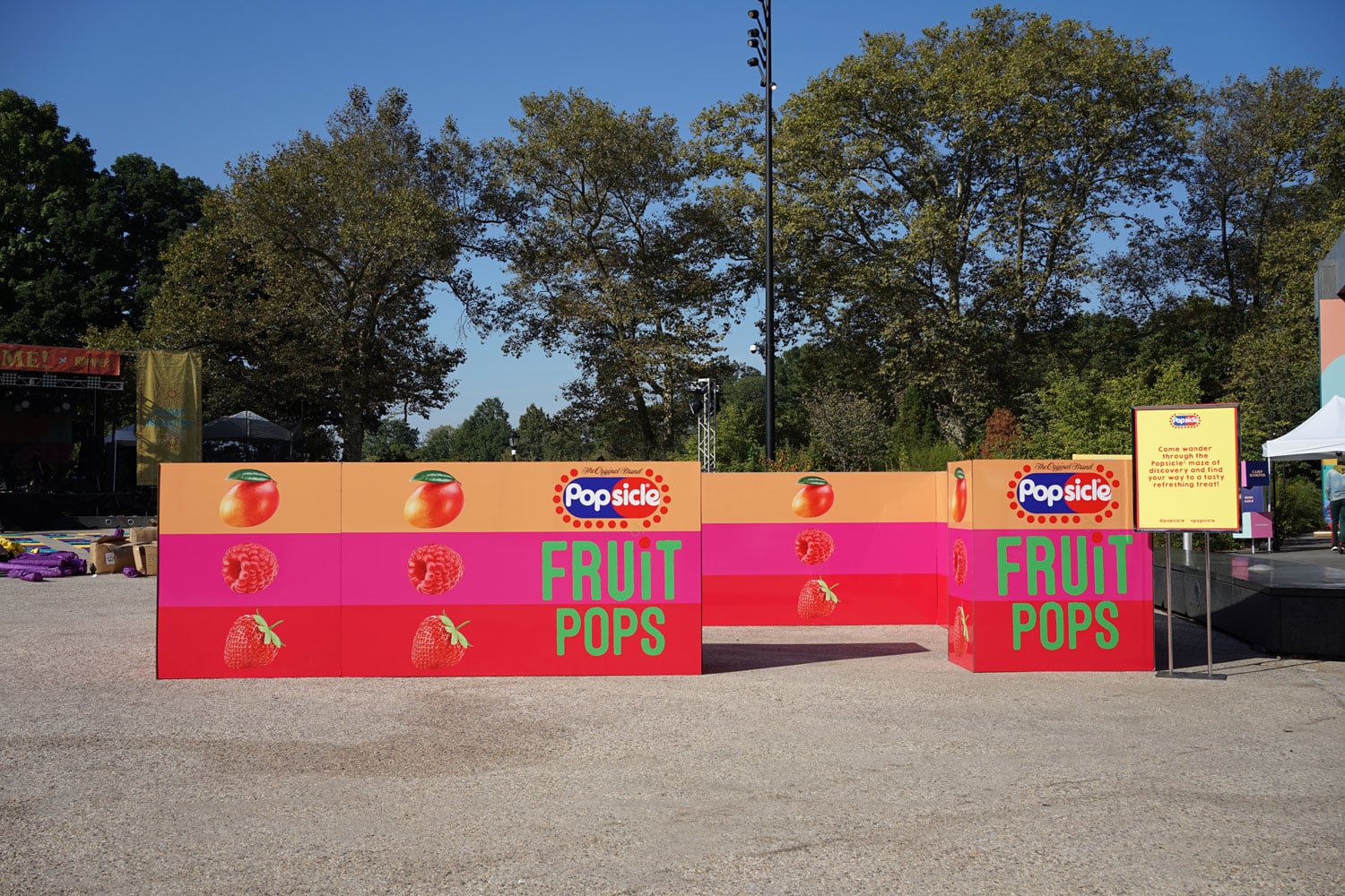 Fruit Pops outdoor experiential marketing booth featuring colorful branding, custom fabrication, LED accents, and immersive event activation design in a festival park environment.